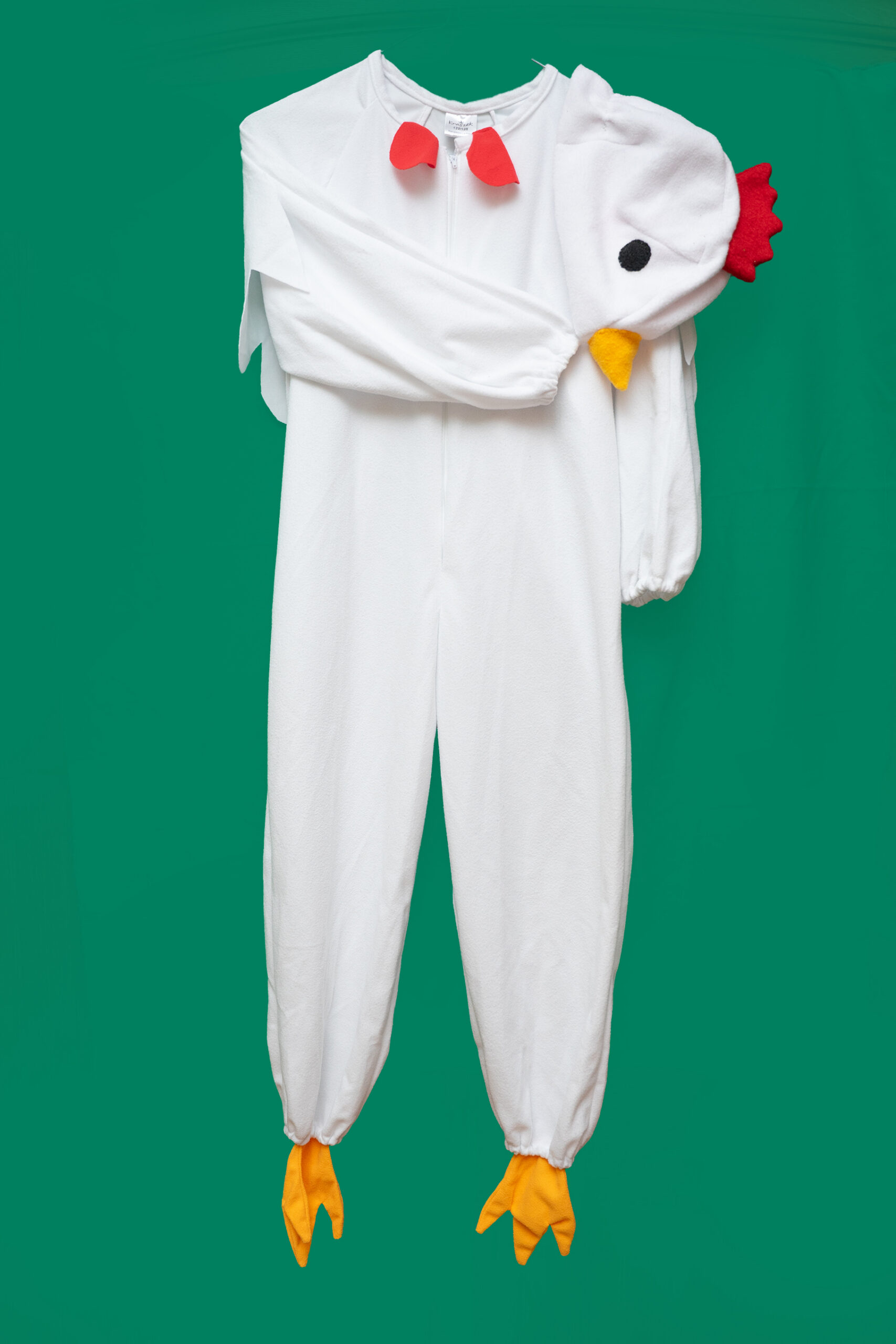 Valge kuke kostüüm kombinesoon koos kuke peakattega rohelisel taustal.