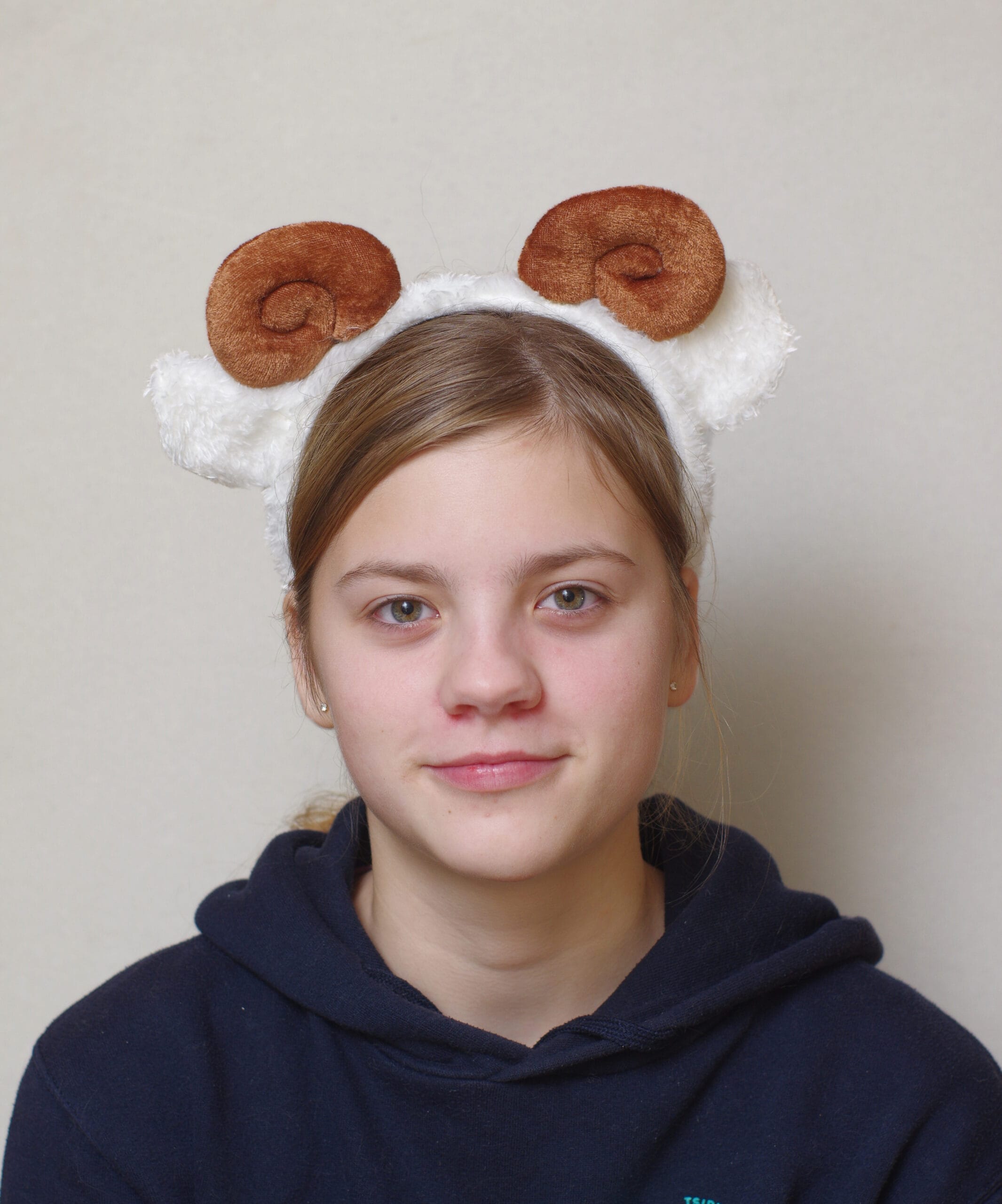 lapsel on peas pruunide keerdus sarvede ja valgete kõrvadega oina peavõru.