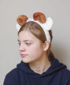 lapsel on peas pruunide keerdus sarvede ja valgete kõrvadega oina peavõru.