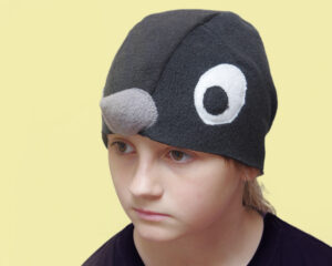 Halli nokaga musta linnu kostüümimüts lapse peas.