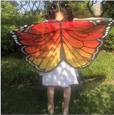 laps, kellel on oranžid õhukesest materjalist liblika tiivad