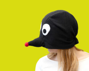 Punase nina ja suurte valgete silmadega fliisist muti kostüümimüts täiskasvanutele. Inimese nägu ei ole näha.