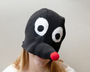 Punase nina ja suurte valgete silmadega fliisist muti kostüümimüts täiskasvanutele. Inimese nägu ei ole näha.