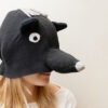 Handmade black bear costume hat made of fleece, featuring a unique white fringe on top and a white nose.