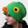 Handmade vibrant green fleece bird hat for adults with an orange beak and large yellow-black eyes.