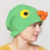 Handmade vibrant green fleece bird hat for adults with an orange beak and large yellow-black eyes.
