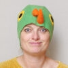 Handmade vibrant green fleece bird hat for adults with an orange beak and large yellow-black eyes.