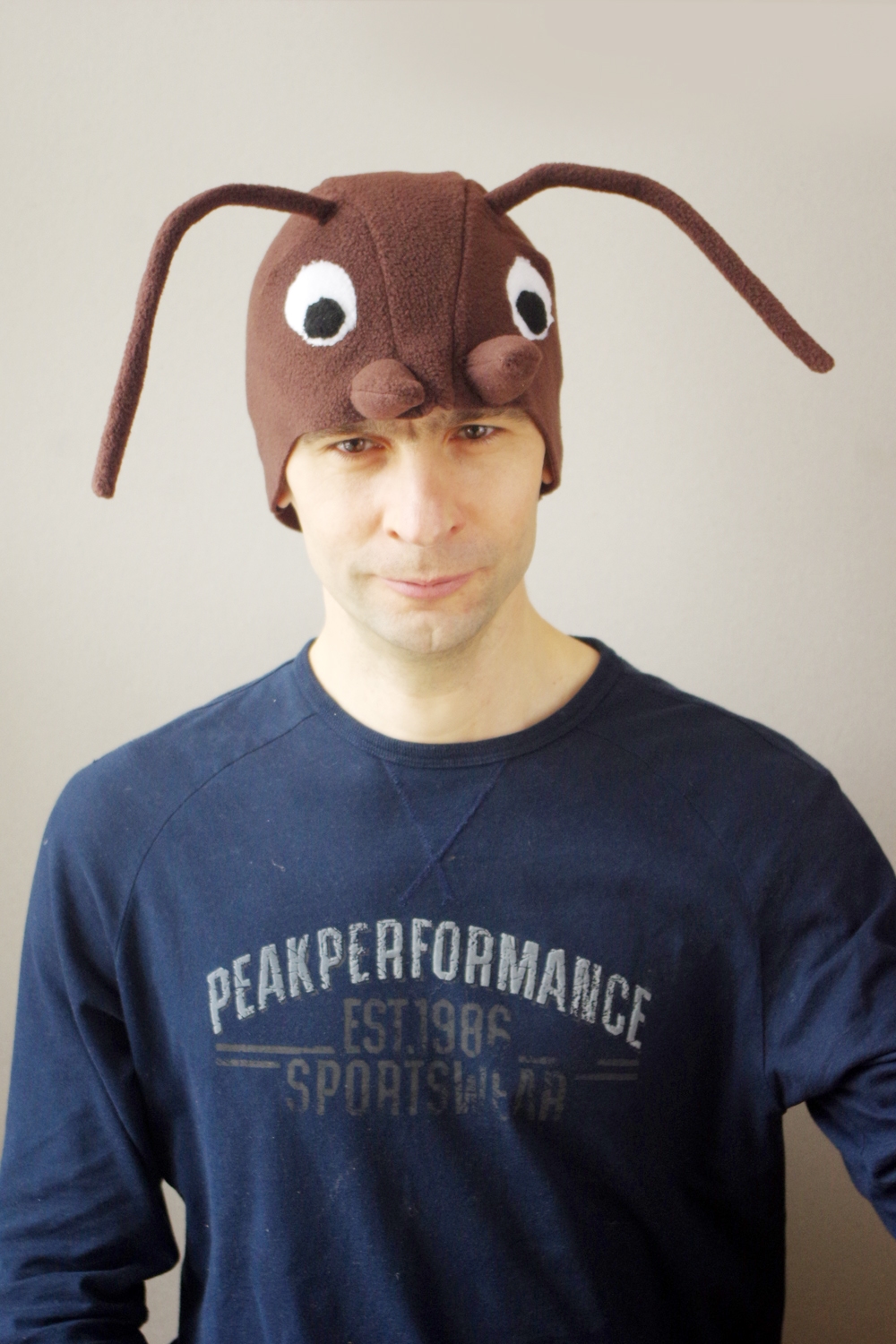 Handmade brown fleece wood ant costume hat for adults. The hat features large white eyes, brown mandibles, and long wired antennae.